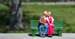 Statue of a couple sitting on a bench while the man kisses the women on the cheek
