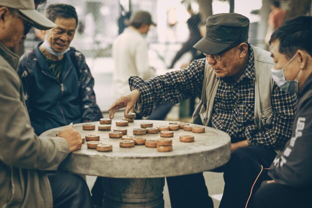 a group of retired men playing a table game